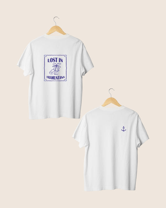 Detalle en el pecho de la camiseta blanca unisex Lost in Tramuntana, con la silueta minimalista de un ancla clásica en color azul tinta.