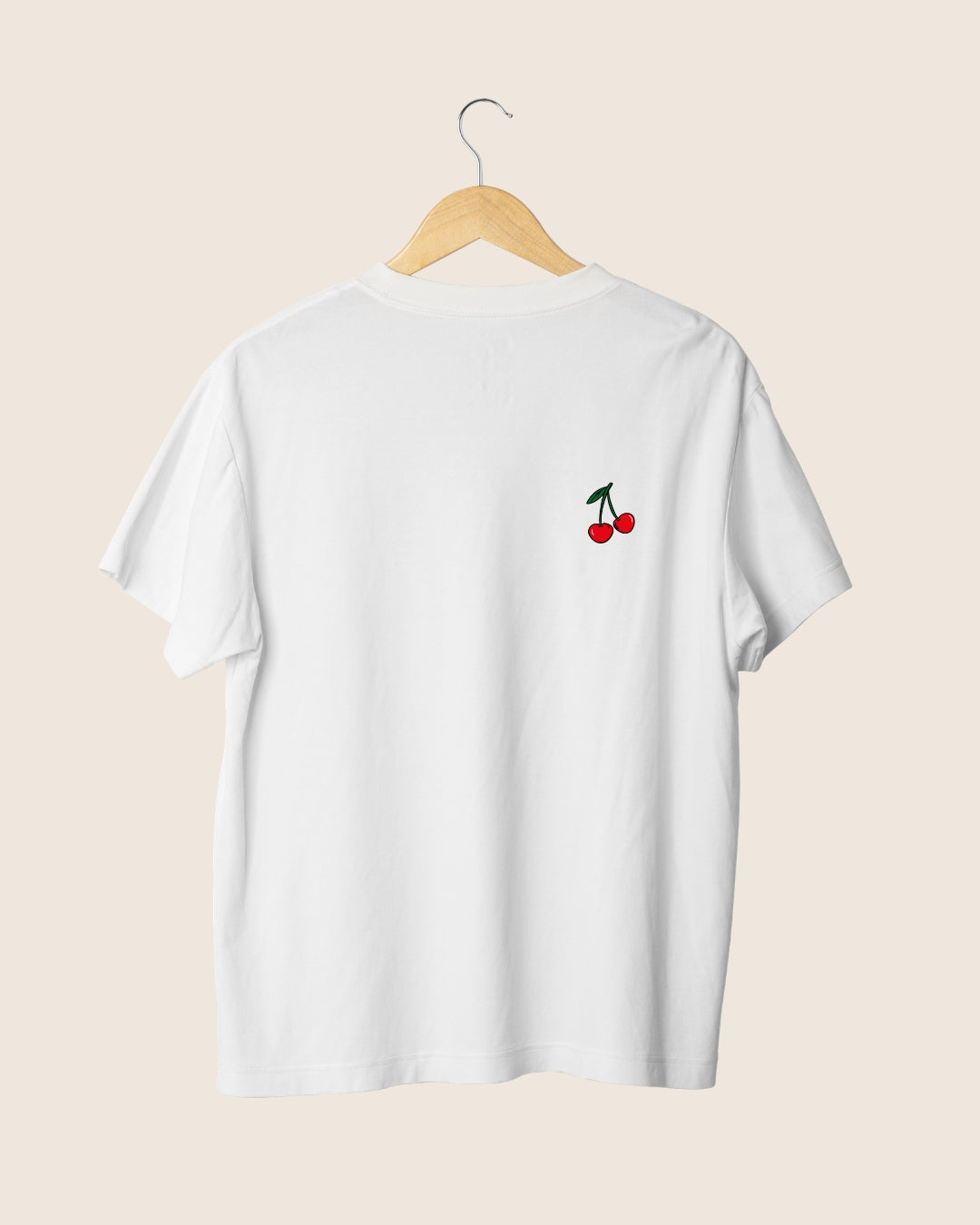 Camiseta blanca unisex con ilustración minimalista en el pecho izquierdo de dos cerezas rojas.