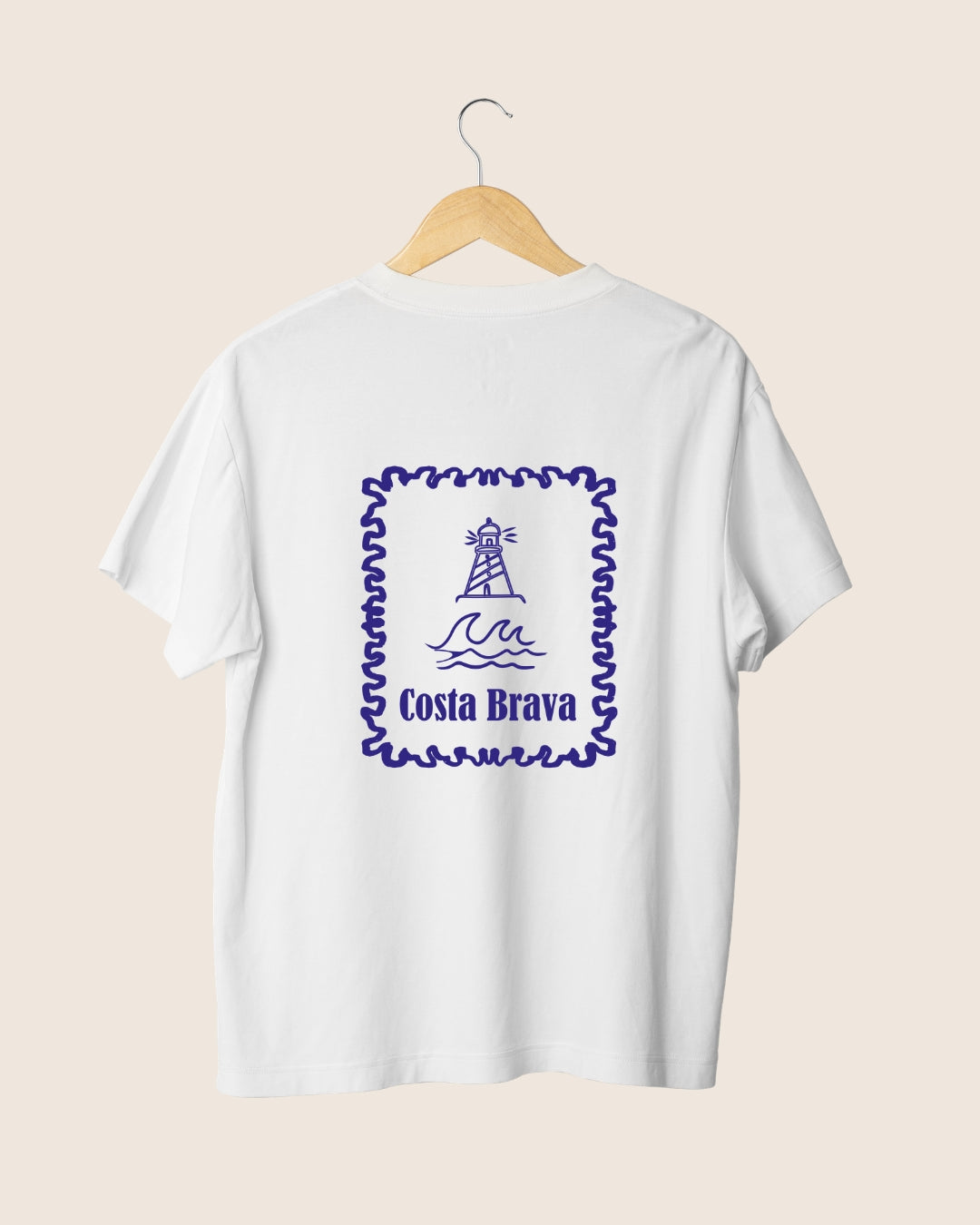Ilustración en la espalda de la camiseta blanca Costa Brava de JR.Ilustracions, con un diseño en formato sello postal que muestra un faro sobre las olas del mar Mediterráneo.