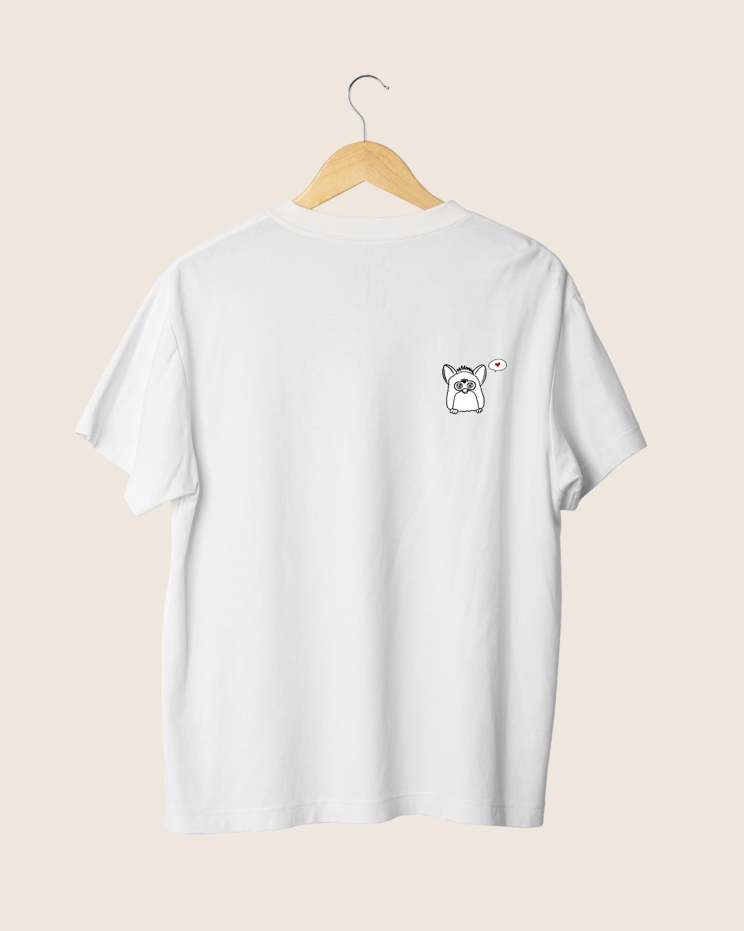 Detalle en el pecho de la camiseta blanca unisex Made For You, con la ilustración de un personaje nostálgico, un bocadillo de texto y un corazón rojo.