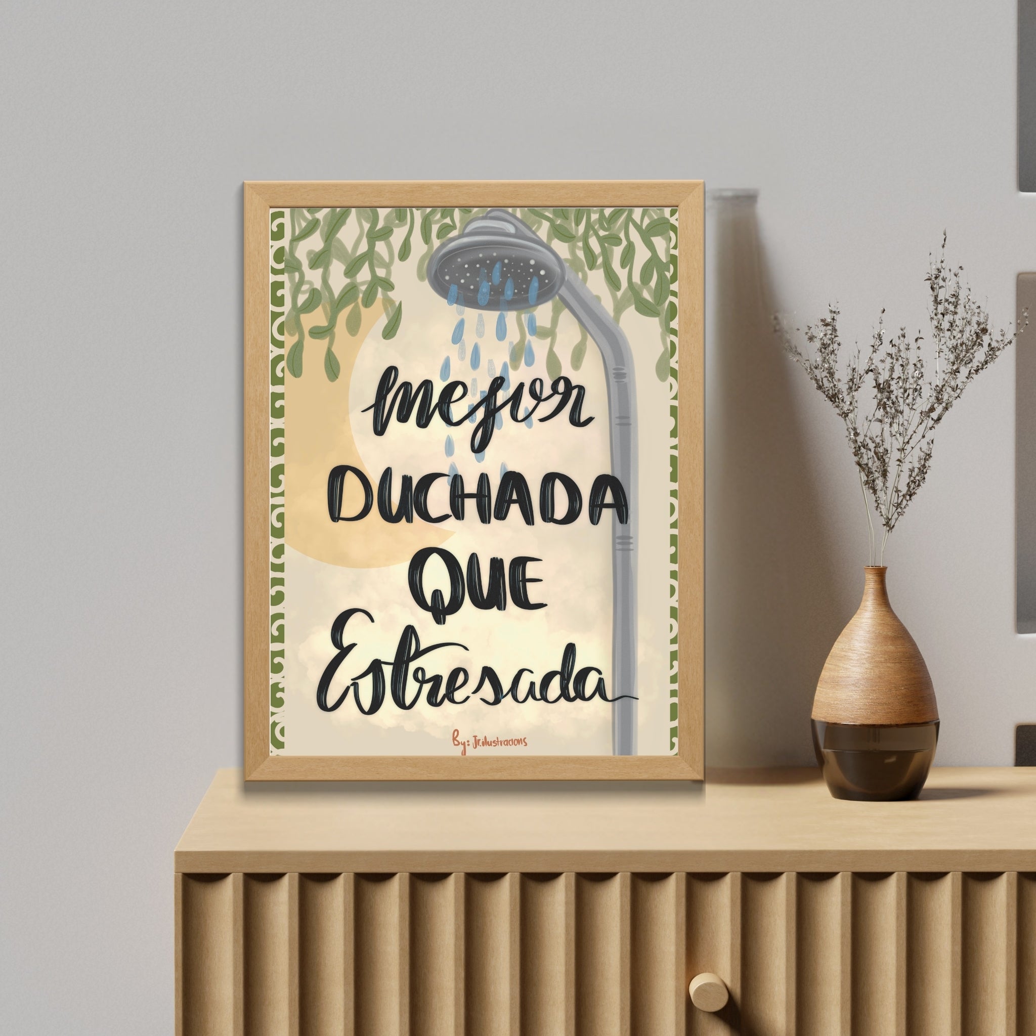 Cuadro para el baño con frase divertida Mejor duchada que estresada y marco de madera clara sobre mueble moderno.