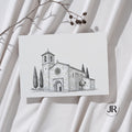 Invitación de boda con sobre texturizado que muestra la ilustración arquitectónica de una iglesia dibujada a plumilla digital.